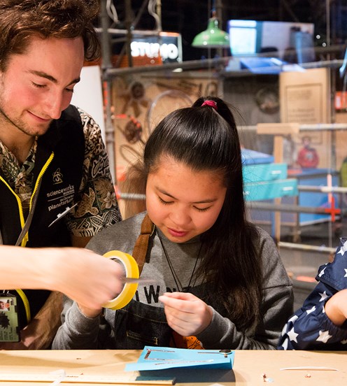 Two girls making a light-up card with a Scienceworks' staff member in Test Lab.
