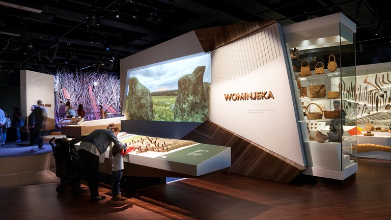 Exhibition entry with visitors looking at language map