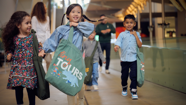 Children carrying Tiny Tours bags.